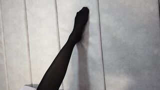 Stretching Sexy Legs and Feet in Black Pantyhose Lying on the Bed